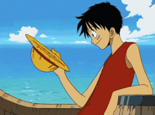 a man in a red shirt is holding a straw hat in his hand