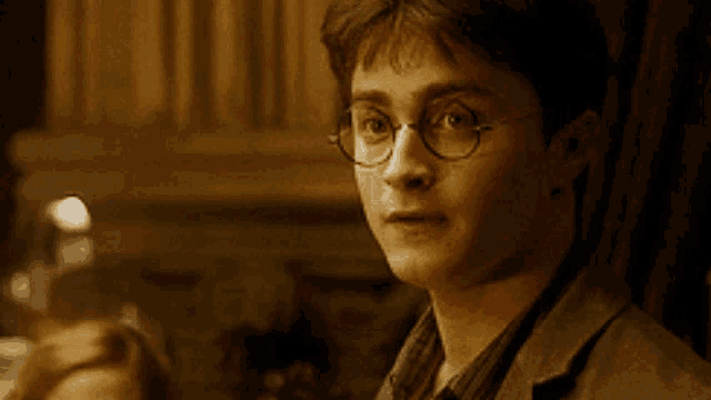 a close up of a man wearing glasses looking to the side
