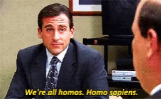 a man in a suit and tie is talking to another man and says " we 're all homos homo sapiens "