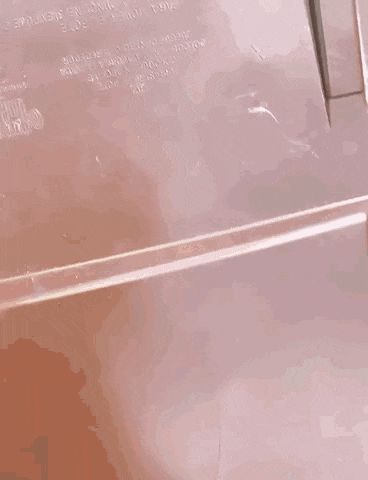 a close up of a brown trash can with a person 's hand sticking out of it