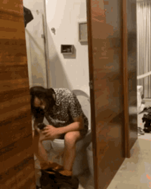 a woman sits on a toilet with her legs crossed
