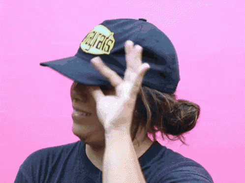 a woman wearing a hat that says ' eagles ' on it is making a peace sign