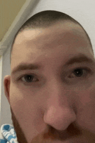 a close up of a man 's face with a beard .