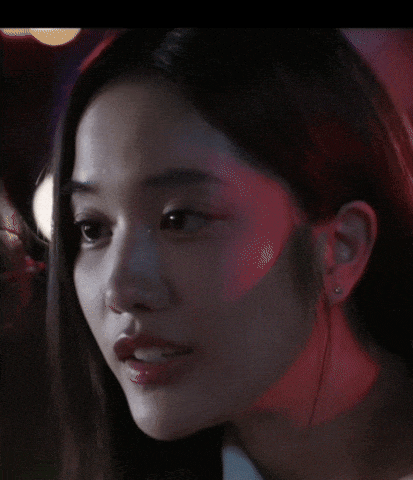 a close up of a woman 's face with a red light behind her ear