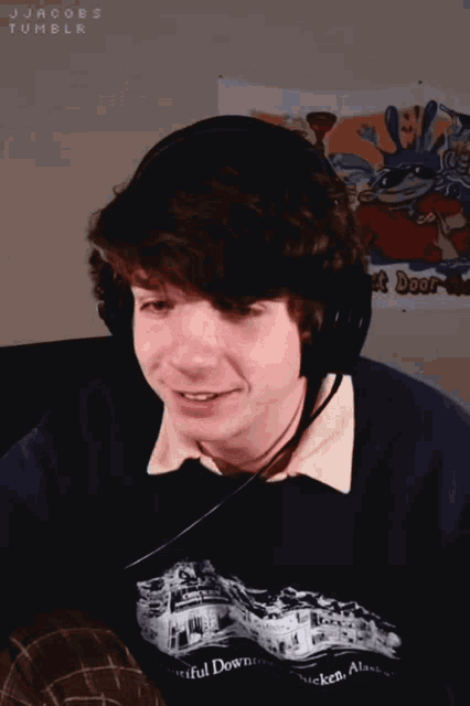 a young man wearing headphones and a shirt that says chicken alaska on it