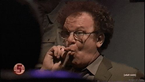 a man smoking a cigarette in front of a screen that says adult swim on it
