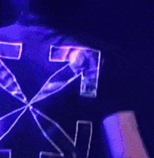 the back of a person wearing a black shirt with a purple arrow on it .