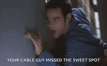 a man is leaning against a wall with the words `` your cable guy missed the sweet spot '' written on the bottom .