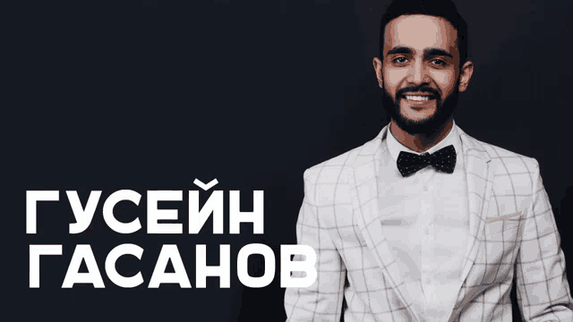a man in a suit and bow tie stands in front of a black background that says guseih gasahob