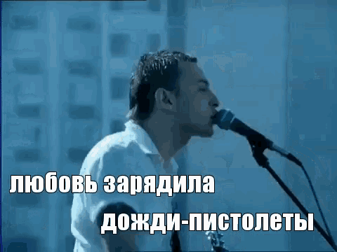 a man singing into a microphone with russian writing