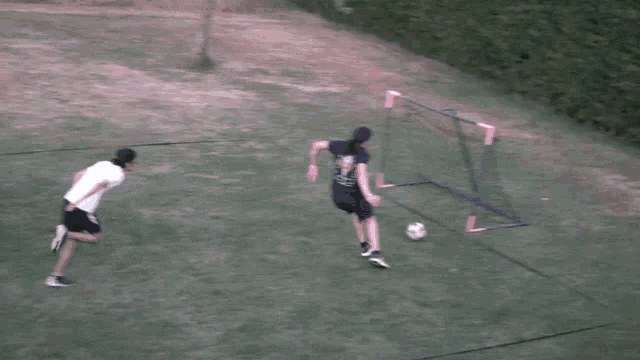 a man wearing a shirt that says ' a ' on it is kicking a soccer ball in front of a goal