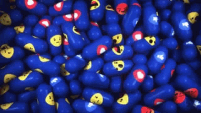 a pile of blue balls with yellow faces on them