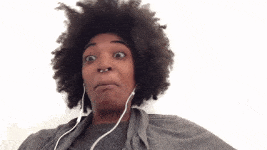 a woman with a nose ring is wearing earbuds and making a funny face