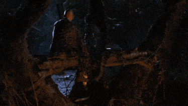 a man is sitting on a log in a forest