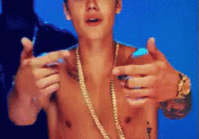 a shirtless man wearing a gold chain and a watch