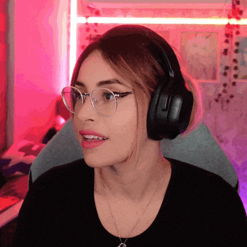a woman wearing glasses and headphones is making a funny face
