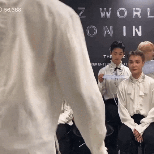 a group of men are sitting in front of a sign that says z world online