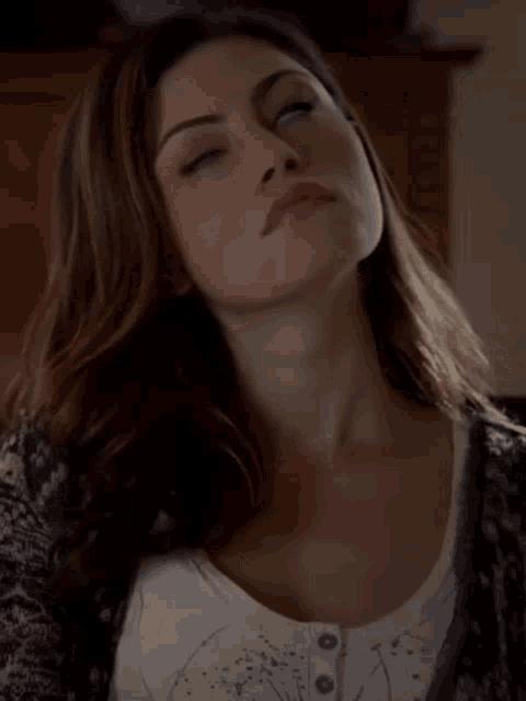 a close up of a woman 's face with a cardigan on