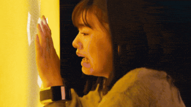 a woman wearing a smart watch looks at a yellow light