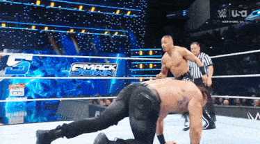 two men in a wrestling ring with the words smack down on the ring
