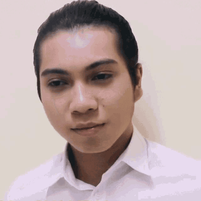 a man in a white shirt is making a funny face with his eyes closed