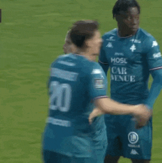 a referee is standing next to a soccer player on the field