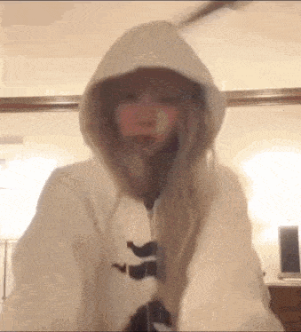 a woman is wearing a white hoodie with a bunny ear .