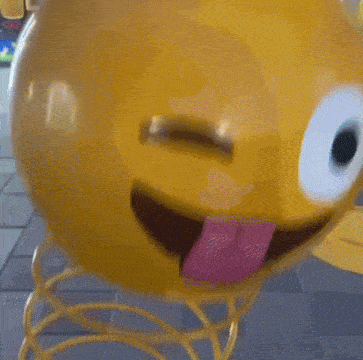 a yellow smiley face on a spring with its tongue out