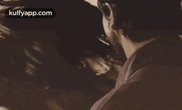 a man and a woman are looking at each other with their hair blowing in the wind in a sepia tone photo .