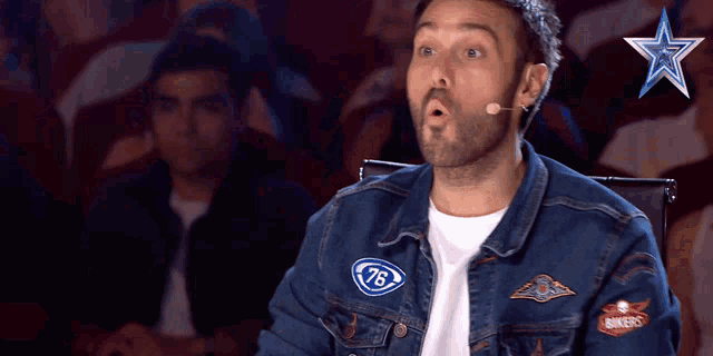 a man wearing a denim jacket with 76 on the front