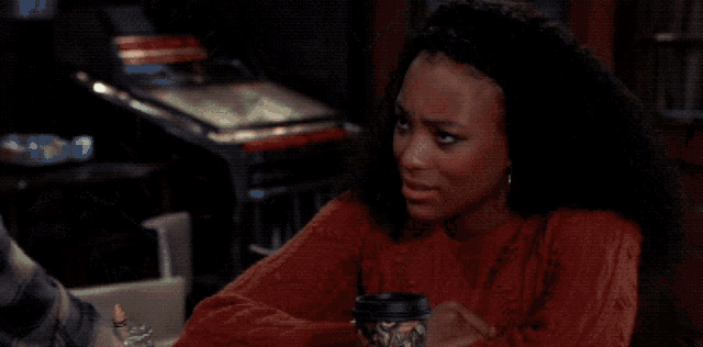 a man in a plaid shirt is talking to a woman in front of a sign that says coca-cola