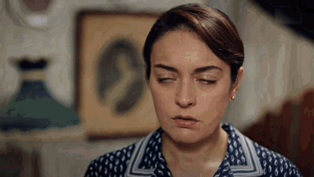 a woman with her eyes closed and a picture in the background