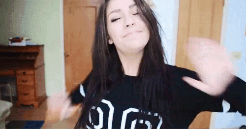 a woman wearing a black sweater with the letter g on it .