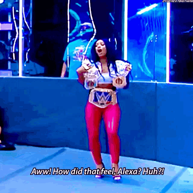 a woman holding a wrestling championship belt says " aww how did that feel alexa huh "