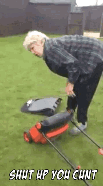 a man is pushing a lawn mower on a lawn with the words shut up you cunt written on the bottom .