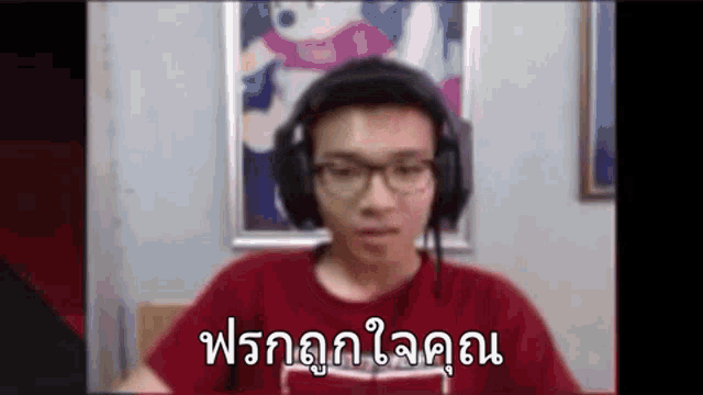 a man wearing headphones and glasses is sitting in front of a computer screen and making a funny face .