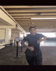 a man in a black shirt is dancing in a room with a sign that says ' frontier ' on it