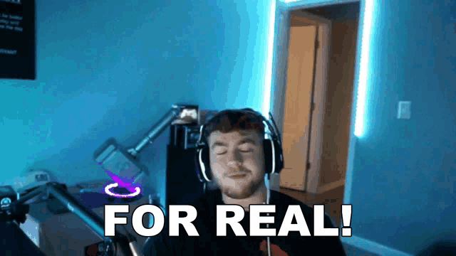 a man wearing headphones says for real in a room