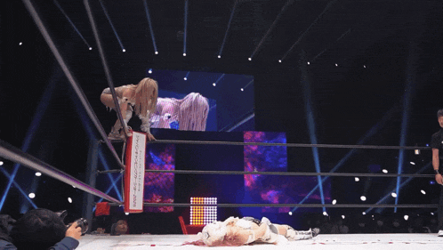 a woman in a wrestling ring is doing a handstand