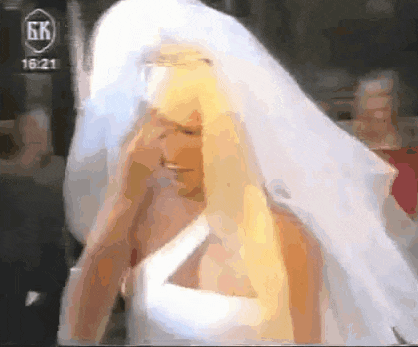 a woman in a wedding dress with a veil and a gk logo on the bottom right