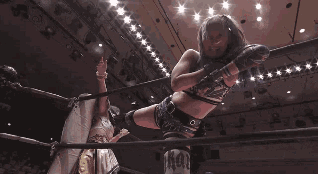 two women are wrestling in a ring and one of them is wearing a shirt that says ' x-ray ' on it