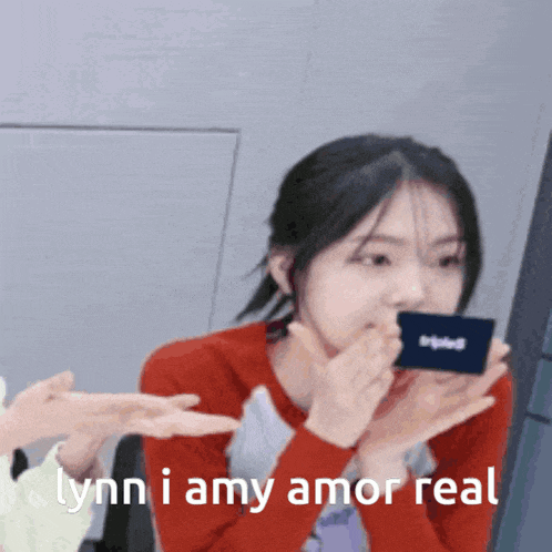 a woman covering her mouth with her hands and the words " lynn i amy amor real " below her