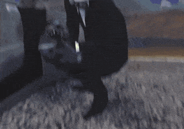 a person walking on a carpeted floor with a green light behind them