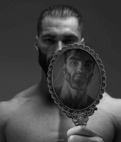 a man with a beard is looking at himself in a hand mirror