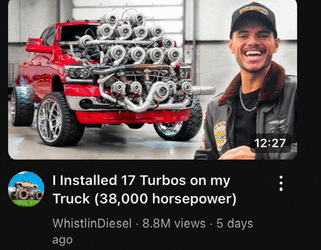 a man is smiling in front of a red truck with a lot of turbos