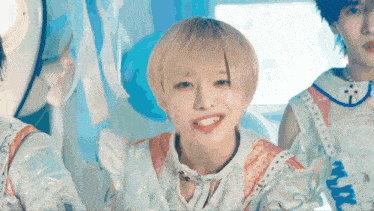a girl with short blonde hair is smiling while wearing a white dress