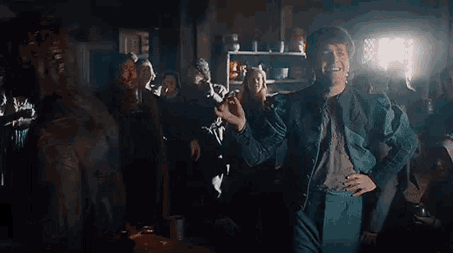 a group of people are dancing in a dark room with candles and drinking beer .