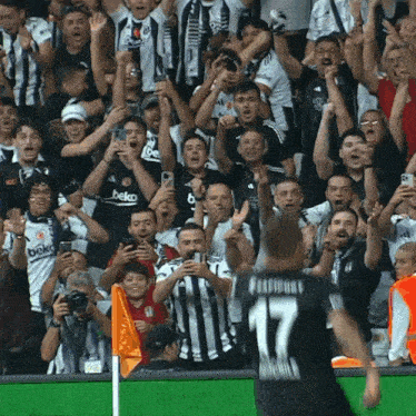 a soccer player with the number 17 on his back stands in front of a crowd