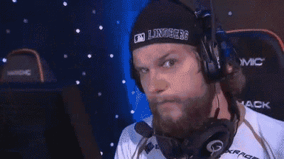 a man with a beard is wearing headphones and a beanie while sitting in front of a computer .