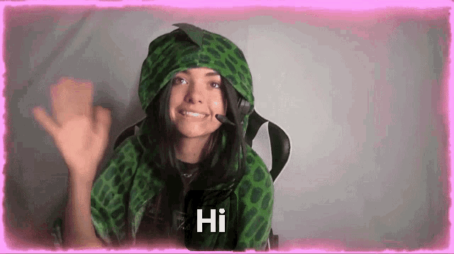 a woman wearing a green leopard print hoodie and a microphone says hi